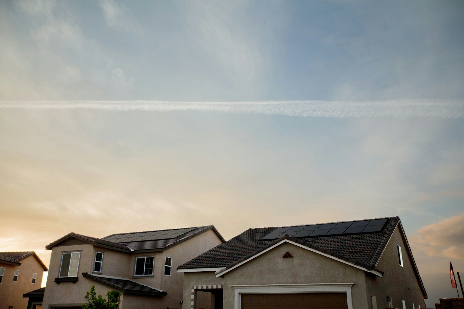 Homes with rooftop solar panels; illustrative Unsplash photograph